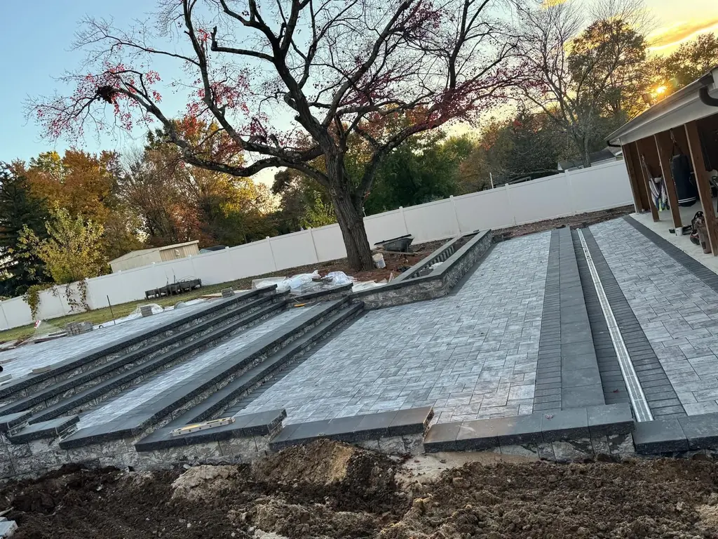 Finished paver patio with wide steps and a raised planter wall